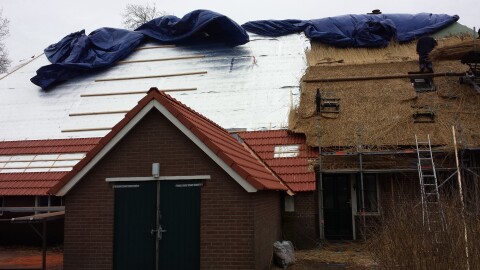 Rieten dakrenovatie halverwege met isolatie en latwerk